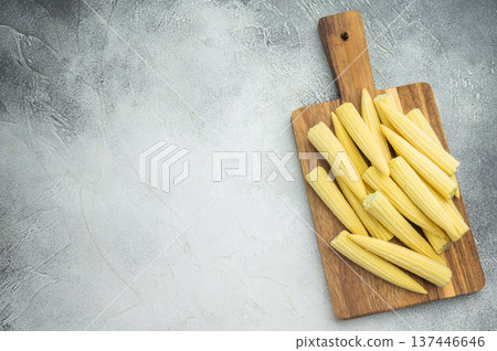 Raw baby corn maize arranged on rustic chopping board top view with copy space ideal for vegetarian recipes and asian cuisine concepts Raw baby corn maize arranged on rustic chopping board top view with copy space ideal for vegetarian recipes and asian cuisine concepts 137446646