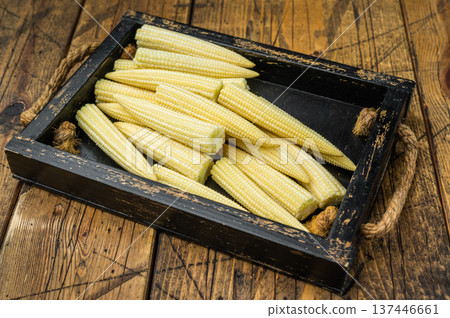 Whole uncooked baby corn in wooden crate on rustic table with thyme flat lay ideal for natural food photography and stock use Whole uncooked baby corn in wooden crate on rustic table with thyme flat lay ideal for natural food photography and stock use 137446661