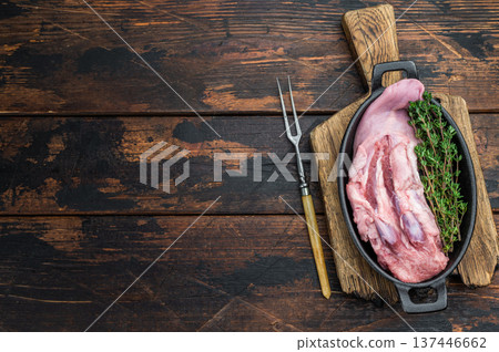 Fresh raw pork tongue meat cut with thyme shown in skillet top view on rustic dark wood backdrop for slow cooking Fresh raw pork tongue meat cut with thyme shown in skillet top view on rustic dark wood backdrop for slow cooking 137446662