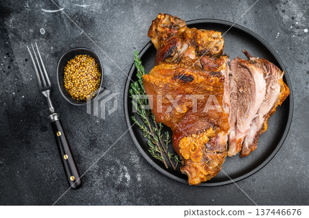 Bavarian roasted knuckle shank with seared rind texture, juicy cross-section and defined muscle fibers presented on matte black dish with thyme. Bavarian roasted knuckle shank with seared rind texture, juicy cross-section and defined muscle fibers presented on matte black dish with thyme. 137446676