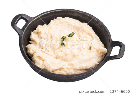 Creamy horseradish sauce in a rustic black cast iron bowl, garnished with a fresh sprig of thyme. Isolated on white background. 137446690