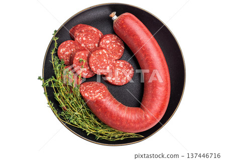 Whole and sliced Turkish sucuk (sujuk) with thyme on a black plate. Spicy dry-cured sausage, isolated on white. Whole and sliced Turkish sucuk (sujuk) with thyme on a black plate. Spicy dry-cured sausage, isolated on white. 137446716