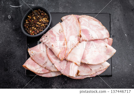 Gourmet Antipasto serving: seasoned Italian cold cuts on a dark surface, highlighting high-contrast composition. 137446717