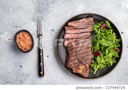 Barbecue dry aged wagyu entrecot steak on plate with salad. grey background. top view Barbecue dry aged wagyu entrecot steak on plate with salad. grey background. top view 137446729