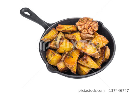 Golden roasted potato wedges with garlic and rosemary in cast iron skillet. Rustic vegetable side dish with copy space Golden roasted potato wedges with garlic and rosemary in cast iron skillet. Rustic vegetable side dish with copy space 137446747