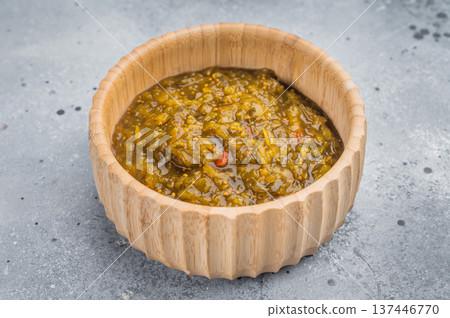 Homemade green Chutney with rich texture in bamboo bowl on gray background studio shot Homemade green Chutney with rich texture in bamboo bowl on gray background studio shot 137446770