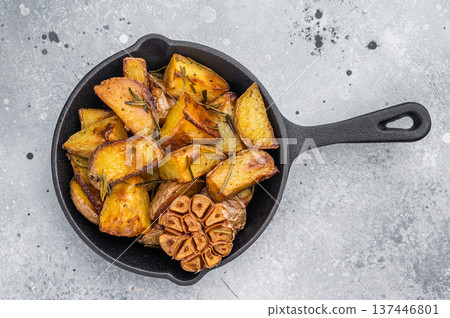Baked potato wedges seasoned with rosemary and garlic in skillet. Simple healthy side dish with copy space Baked potato wedges seasoned with rosemary and garlic in skillet. Simple healthy side dish with copy space 137446801