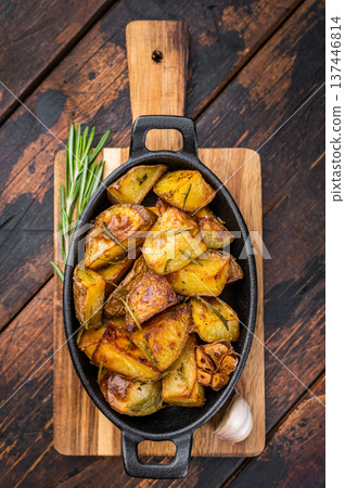Baked potatoes with rosemary and garlic in cast iron pan. Simple rustic vegetable side dish overhead view 137446814