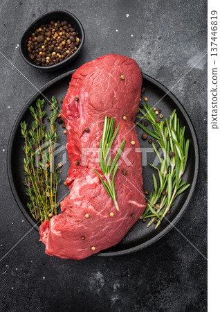 Fresh raw beef meat with rosemary and thyme prepared for roasting. High quality protein for homemade roast beef and gourmet dishes. Fresh raw beef meat with rosemary and thyme prepared for roasting. High quality protein for homemade roast beef and gourmet dishes. 137446819