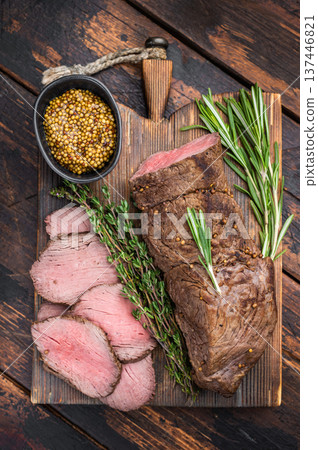 Classic roast beef medium rare with thyme rosemary and spices on rustic board dark background overhead food photo Classic roast beef medium rare with thyme rosemary and spices on rustic board dark background overhead food photo 137446821