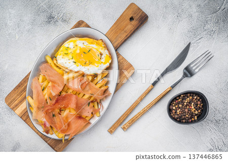 Spanish huevos rotos with broken eggs fries and cured ham Jamon on ceramic plate overhead copy space Spanish huevos rotos with broken eggs fries and cured ham Jamon on ceramic plate overhead copy space 137446865