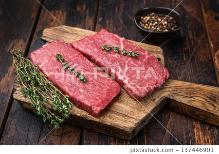 Raw wagyu beef topside top round with thyme on wooden board. Dark rustic background premium red meat with copy space. Raw wagyu beef topside top round with thyme on wooden board. Dark rustic background premium red meat with copy space. 137446901