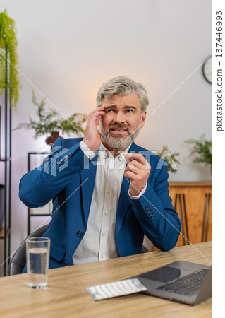 Middle-aged businessman massages temples swallows headache pill drinks water again to return to work Middle-aged businessman massages temples swallows headache pill drinks water again to return to work 137446993