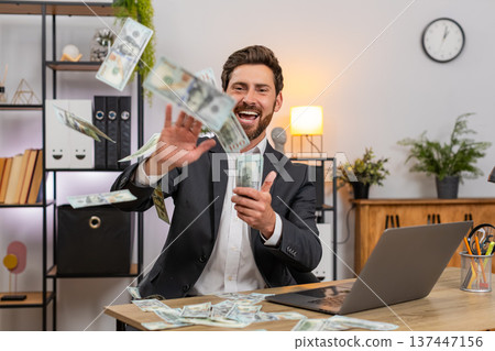 Middle-aged businessman tosses dollar cash makes money rain laughs shares donation with others big Middle-aged businessman tosses dollar cash makes money rain laughs shares donation with others big 137447156