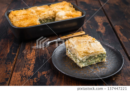 Traditional Greek spanakopita phyllo pie with spinach cheese filling, golden baked crust and sesame topping Traditional Greek spanakopita phyllo pie with spinach cheese filling, golden baked crust and sesame topping 137447221