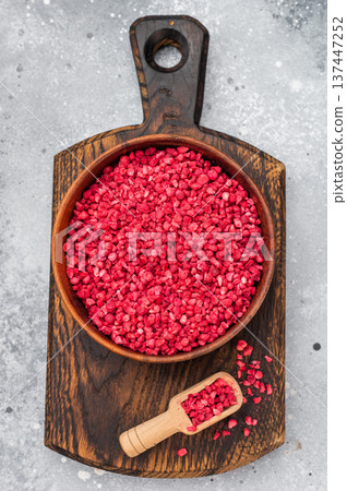 Sublimated raspberry granules with bright red color in wooden bowl. Natural berry texture with copy space flatlay. Sublimated raspberry granules with bright red color in wooden bowl. Natural berry texture with copy space flatlay. 137447252