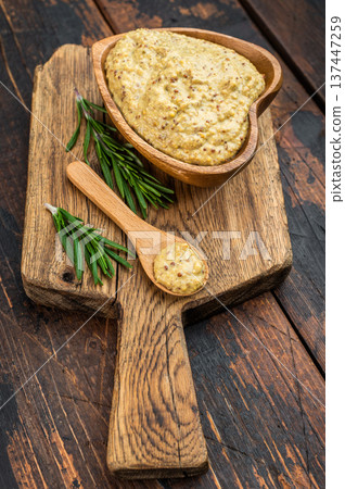 Bavarian sweet mustard with mild grainy texture in wooden bowl with spoon and rosemary flat lay on rustic wood background Bavarian sweet mustard with mild grainy texture in wooden bowl with spoon and rosemary flat lay on rustic wood background 137447259