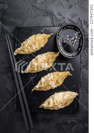 Steamed Chinese Jiaozi Dumplings with meat and vegetables on marble board. black background. top view 137447301