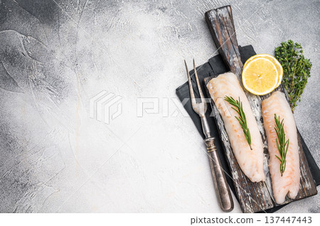 Raw cod Loin, white fish fillets without skin on wooden board. white background. top view Raw cod Loin, white fish fillets without skin on wooden board. white background. top view 137447443
