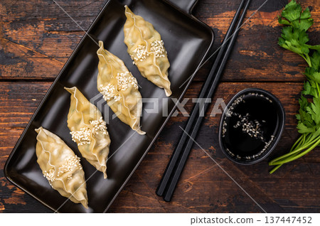 Traditional Chinese Jiaozi Dumplings with pork meat and vegetables. wooden background. top view Traditional Chinese Jiaozi Dumplings with pork meat and vegetables. wooden background. top view 137447452
