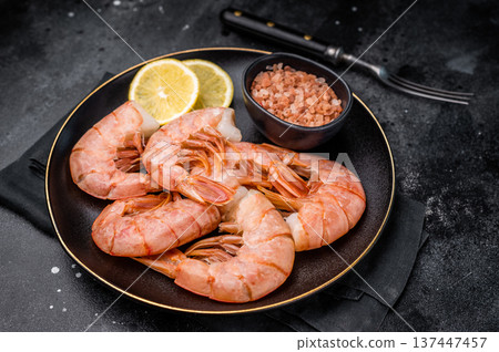 Uncooked Headless Red shrimps, raw Prawns on plate. black background. top view Uncooked Headless Red shrimps, raw Prawns on plate. black background. top view 137447457