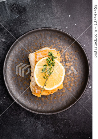 Roast Halibut fish loin fiilet on plate. Black background. top view Roast Halibut fish loin fiilet on plate. Black background. top view 137447458