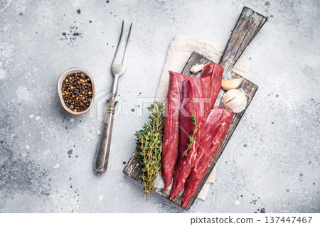 Raw lamb tenderloin fillet pieces, fresh mutton meat on wooden board. grey background. top view 137447467