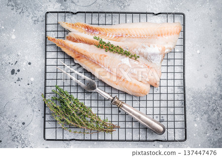 Raw pollock white fish fillet with thyme. grey background. top view Raw pollock white fish fillet with thyme. grey background. top view 137447476