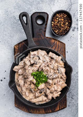 Creamy beef stroganoff with fresh greenery, savory mushroom sauce and caramelized onions in a skillet. grey background. top view Creamy beef stroganoff with fresh greenery, savory mushroom sauce and caramelized onions in a skillet. grey background. top view 137447490
