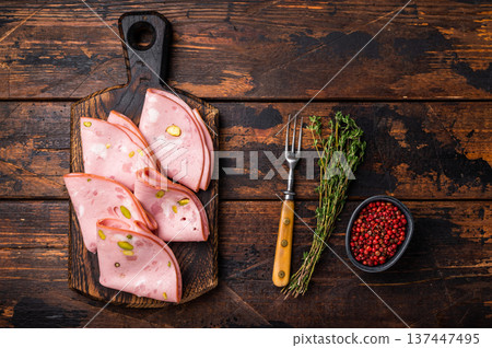 Italian Mortadella sausage slices with pistachios on wooden cutting board. wooden background. top view Italian Mortadella sausage slices with pistachios on wooden cutting board. wooden background. top view 137447495