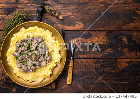 Beef Stroganoff over mashed potatoes with creamy sauce in a plate. wooden background. top view Beef Stroganoff over mashed potatoes with creamy sauce in a plate. wooden background. top view 137447496