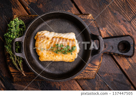 Roasted cod fish loin fiilet in skillet. Wooden background. top view 137447505
