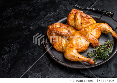 Roasted chicken Tabaka with herbs and spices, poultry meat on steel tray. black background. top view Roasted chicken Tabaka with herbs and spices, poultry meat on steel tray. black background. top view 137447506