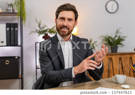Middle-aged businessman consultant presents on camera smiles and speaks during video conference live Middle-aged businessman consultant presents on camera smiles and speaks during video conference live 137447623