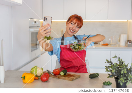 Young woman blogger records selfie video on smartphone shows salad bowl and promotes healthy eating 137447668