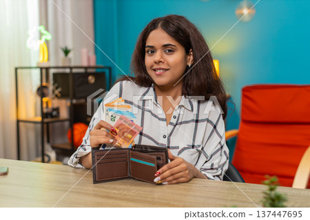 Indian rich woman counting euro cash placing bills into wallet feeling satisfied, proud wealth calm 137447695