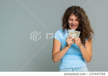 Woman hold dollar cash money smiling satisfied celebrating salary savings loan financial success joy Woman hold dollar cash money smiling satisfied celebrating salary savings loan financial success joy 137447766