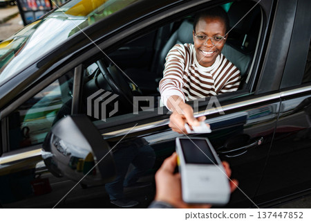 Woman paying for gas using credit card at station 137447852