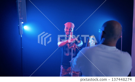 Male singer performing, recording music video on phone Male singer performing, recording music video on phone 137448274