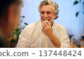 Happy senior man laughing enjoying dinner with friends 137448424