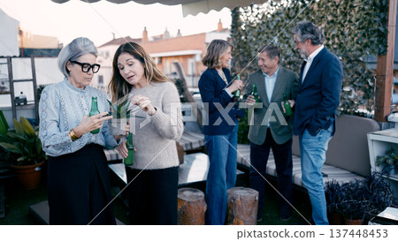Senior adult friends enjoying drinks at rooftop party 137448453