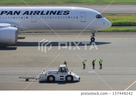 地勤人員向即將離港的客機揮手道別 地勤人員向即將離港的客機揮手道別 137449242