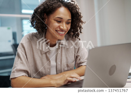 Friendly Woman Smiling While Assisting Customers Through Digital Communication From Remote Location 137451767