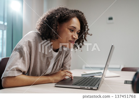 Dedicated Female Worker Reviewing Spreadsheet Details While Sitting In Quiet Modern Workspace Dedicated Female Worker Reviewing Spreadsheet Details While Sitting In Quiet Modern Workspace 137451768