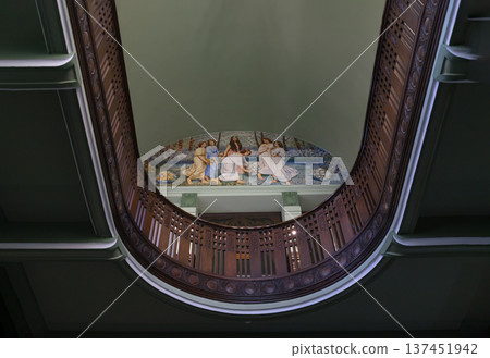 This upward-looking perspective highlights the neoclassical and colonial influences of the Bang Khun Phrom Palace interior. The composition is centered on a semi-circular mezzanine balcony featuring a 137451942