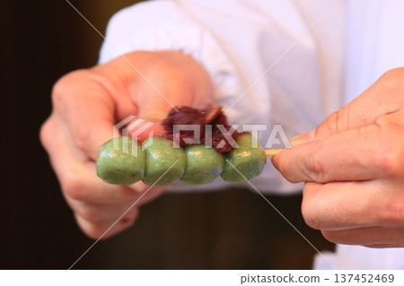 A craftsman pours bean paste into Kusa-dango dumplings A craftsman pours bean paste into Kusa-dango dumplings 137452469