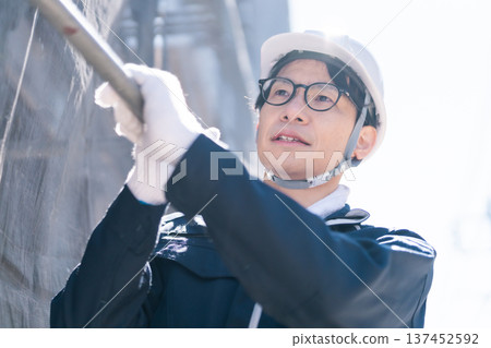 Male craftsman dismantling and assembling scaffolding at a construction site Male craftsman dismantling and assembling scaffolding at a construction site 137452592