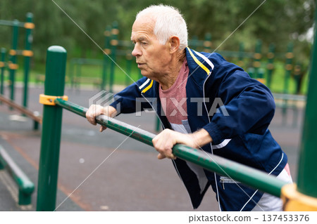 Senior european man doing push-ups outdoors Senior european man doing push-ups outdoors 137453376