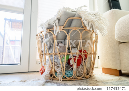 Woven rattan basket with cozy blankets and yarn in Scandinavian home interior Woven rattan basket with cozy blankets and yarn in Scandinavian home interior 137453471