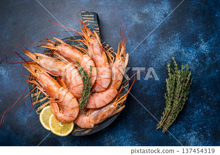 Ready for cooking Red Argentine shrimps, raw Prawns Langostino Austral on wooden board. blue background. top view Ready for cooking Red Argentine shrimps, raw Prawns Langostino Austral on wooden board. blue background. top view 137454319